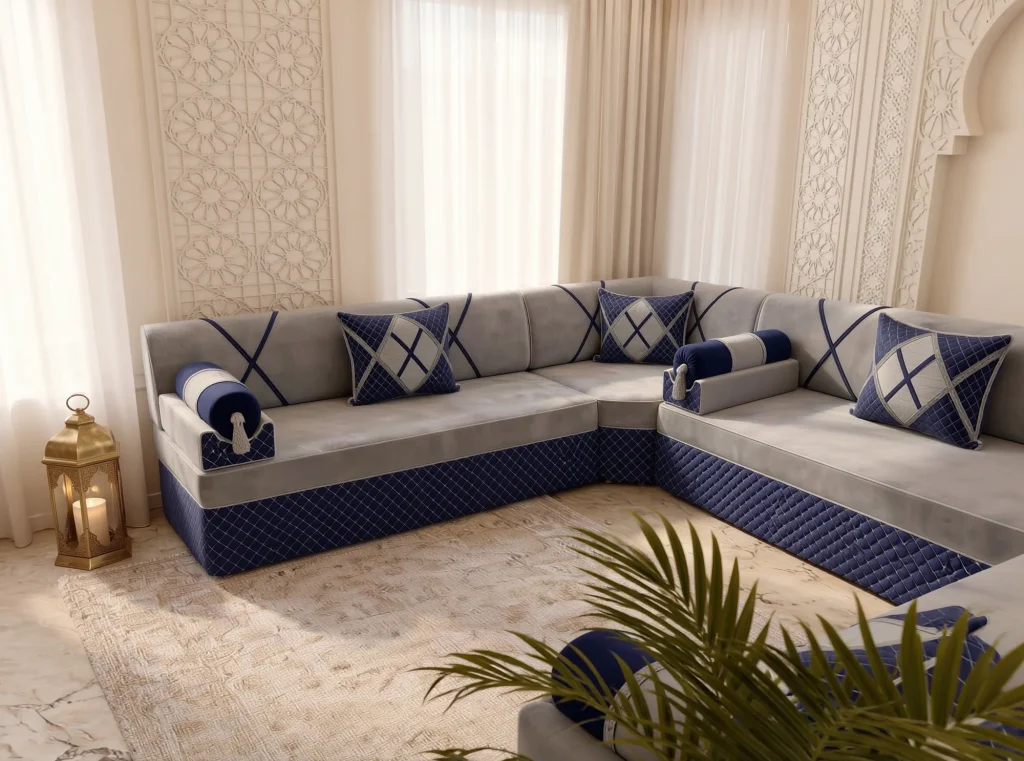 Light grey and navy majlis sofa set in a window corner beside a carved lattice panel and brass lantern