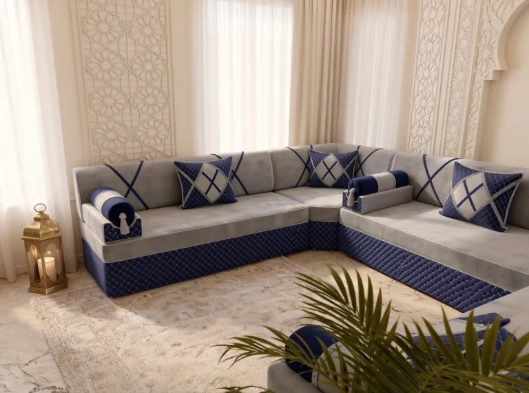 Light grey and navy majlis sofa set in a window corner beside a carved lattice panel and brass lantern