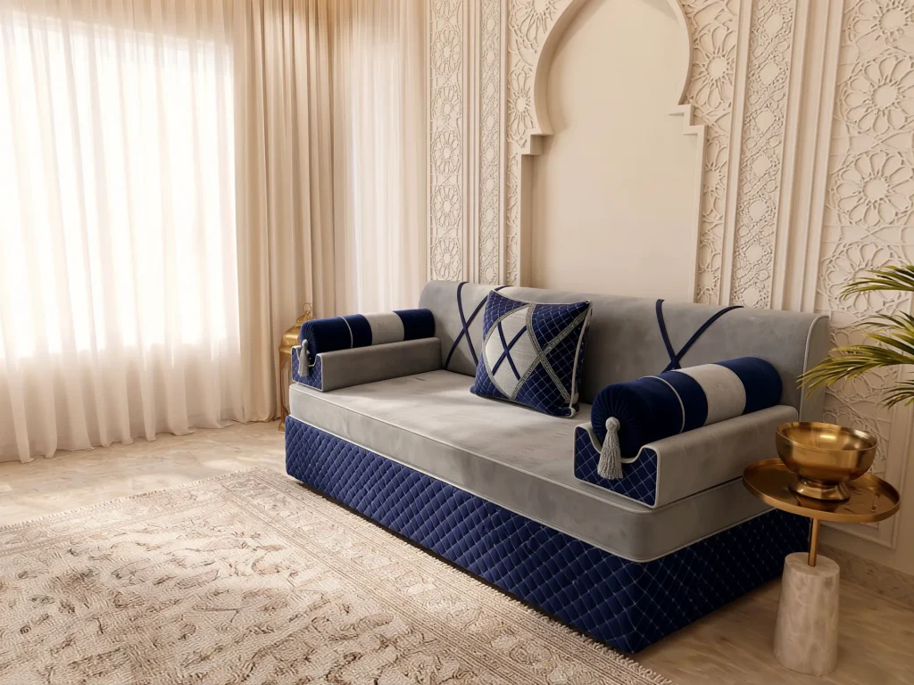 Single light grey and navy majlis seating set with bolster armrests angled toward a sunlit window