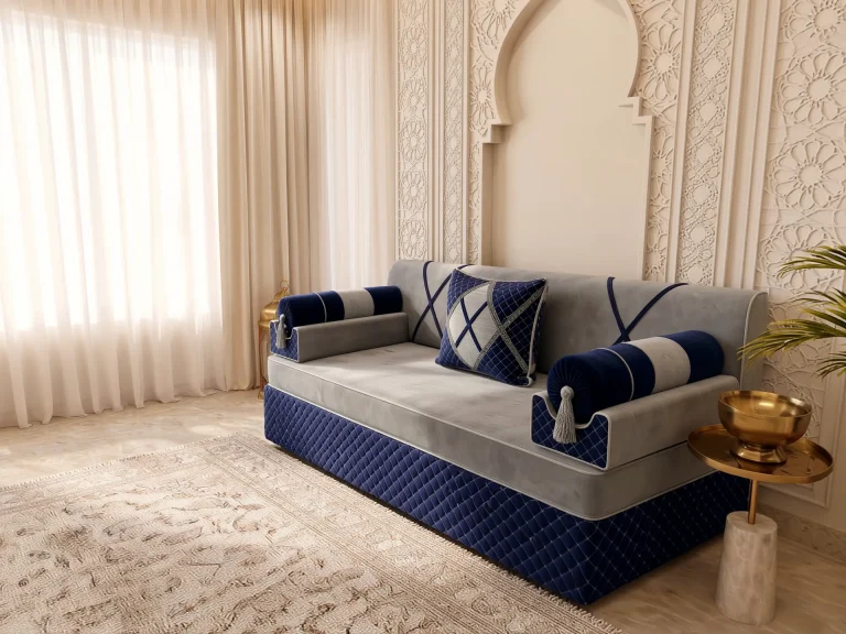 Single light grey and navy majlis seating set with bolster armrests angled toward a sunlit window