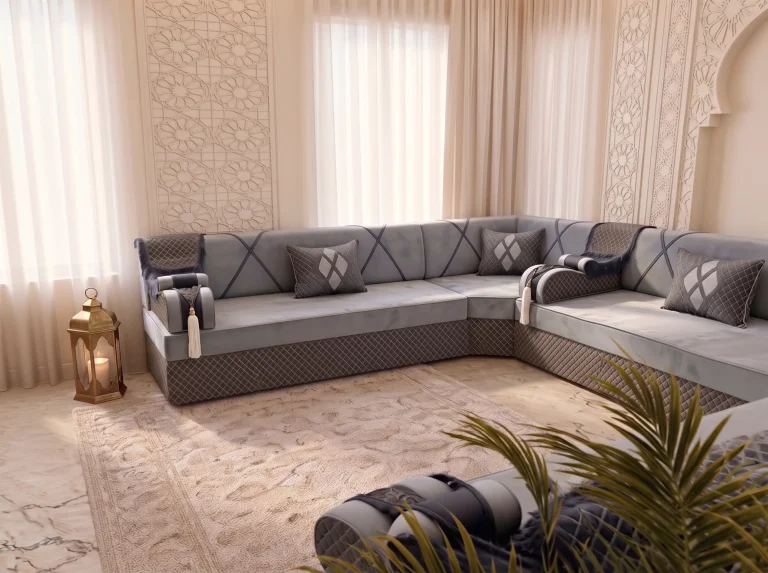 Grey velvet Arabic majlis with a quilted base seen across a corner, brass lantern at left and palm in front