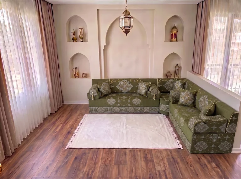 Khaki green medallion-damask majlis sofa in an L shape with a white fringed rug by arched niches