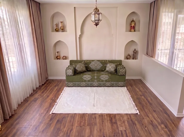 Khaki green medallion-damask majlis sofa as a single row with a white fringed rug by arched niches