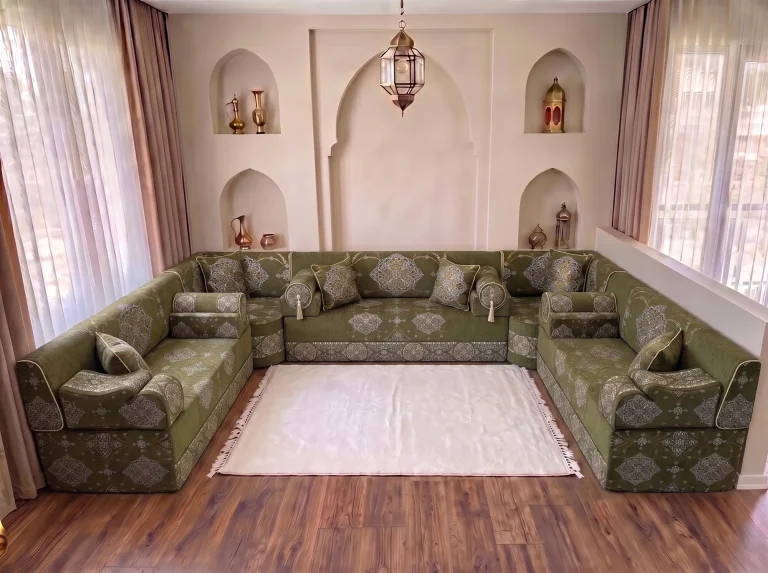 Khaki green medallion-damask Arabic majlis with bolster armrests in a U shape with a white fringed rug by arched niches