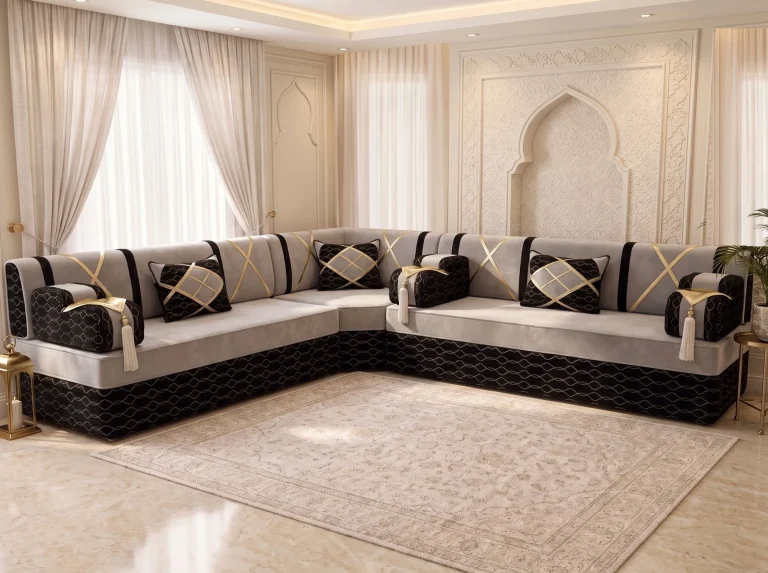 L-shaped light grey majlis seating set with black armrests, gold crossed straps and three black and gold cushions