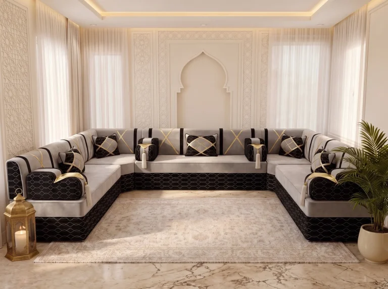 U-shaped light grey and black majlis sofa with gold crossed straps lining three walls around a cream rug