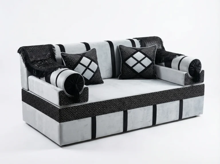 Light grey velvet majlis seating piece with black key-pattern jacquard bands, black fringed throws and two cushions