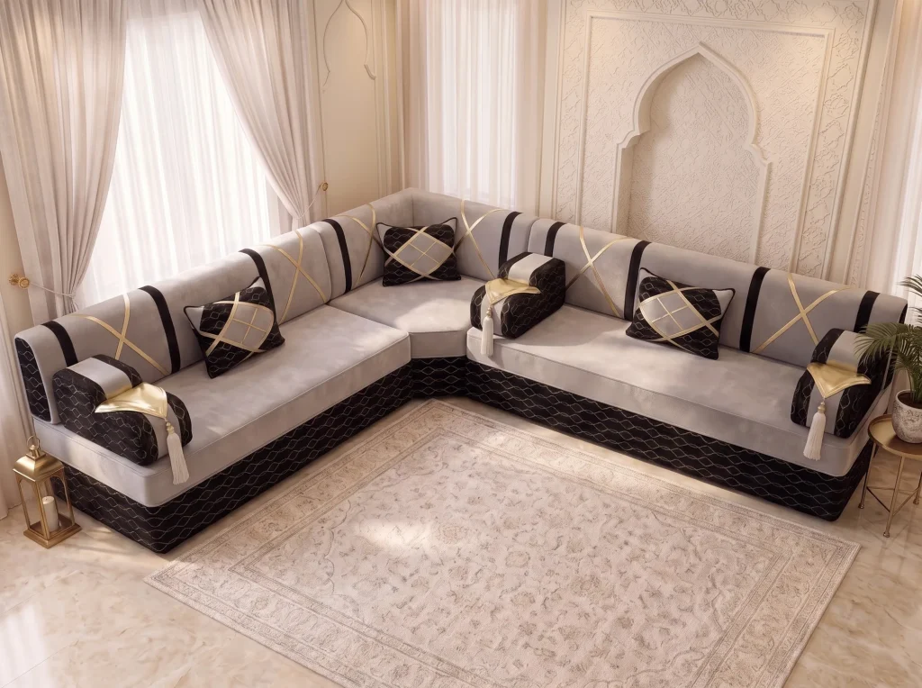 High-angle view of an L-shaped light grey and black Arabic majlis with gold crossed straps beside a cream rug