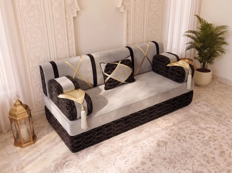 High-angle view of a single light grey majlis sofa seat with black armrests, gold flaps and white tassels