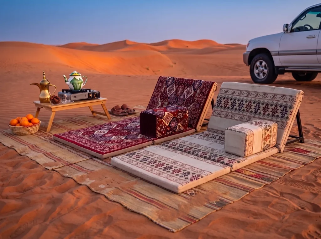 Maroon and beige Arabic sunbed loungers side by side on striped kilims beside a white 4x4