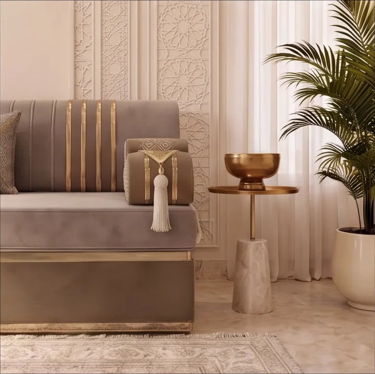 End of a beige velvet majlis sofa set with a gold-striped back and tasselled armrest beside a brass bowl on a side table