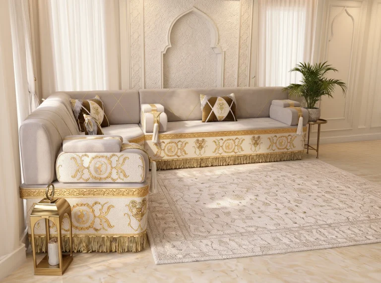 Beige Arabic majlis in an L shape with gold baroque-embroidered cream bases and fringe, seen from the left end