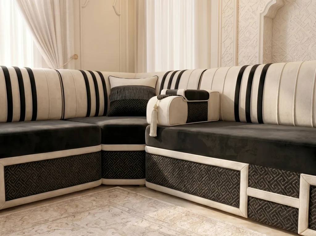 Close view of a black velvet Arabic jalsa corner seat with cream striped backs and black key-pattern base panels