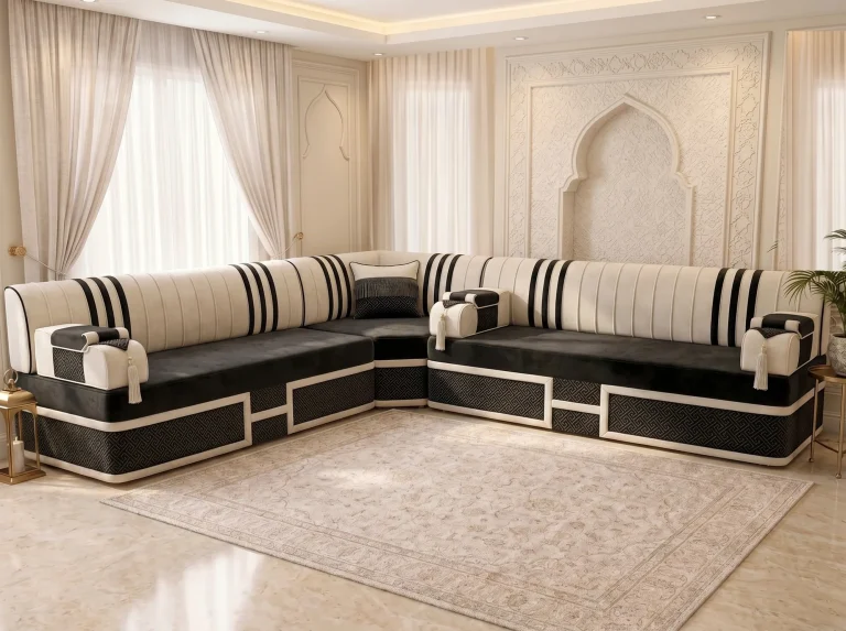 Black velvet majlis sofa in an L shape with cream black-striped backs and framed key-pattern bases before a carved arch