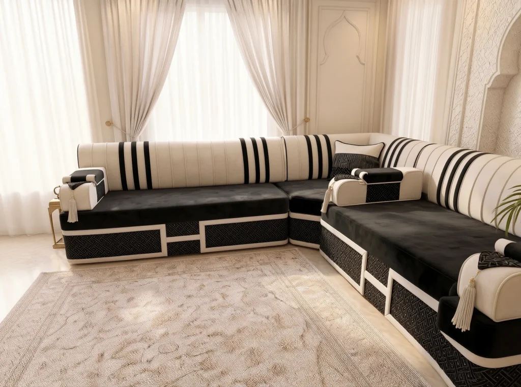 Black velvet L-shaped majlis with cream striped backs by sheer curtains