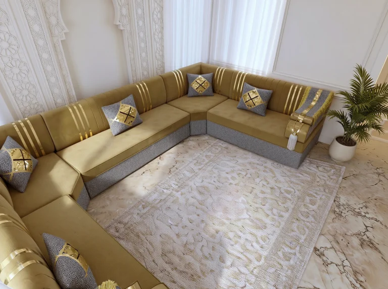 Overhead corner view of a mustard velvet Arabic majlis with gold stripes and grey bases wrapping a beige rug on marble