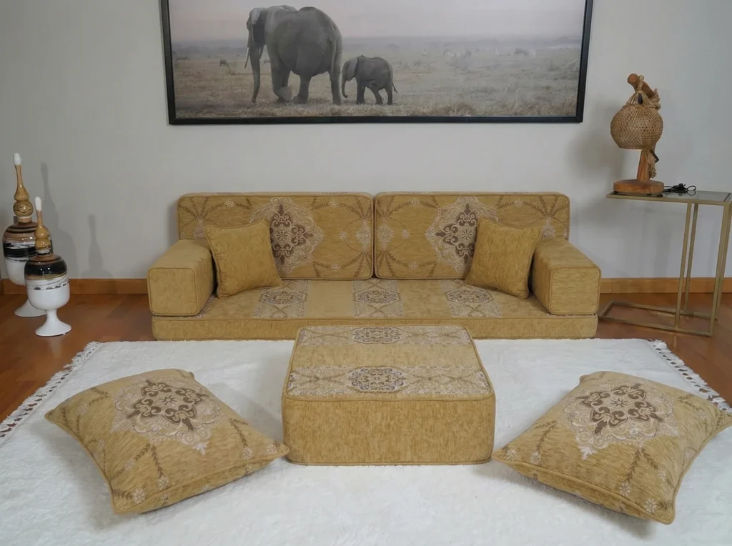 Mustard yellow Arabic sofa at floor level with brown medallion cushions, ottoman and floor cushions