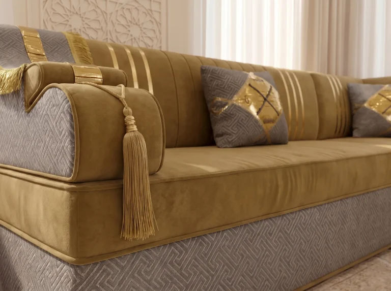 Close-up of a mustard velvet armrest with a long gold tassel on a majlis sofa set with a grey key-pattern base