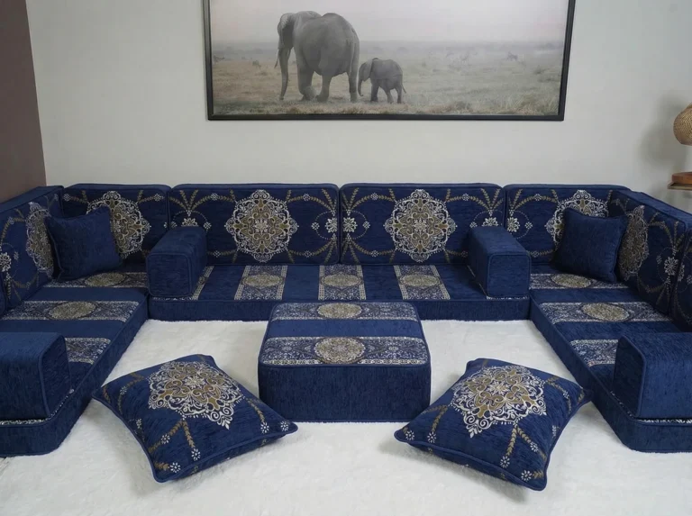 Navy chenille diwan floor sofa in a U shape with gold medallion back cushions around a matching ottoman