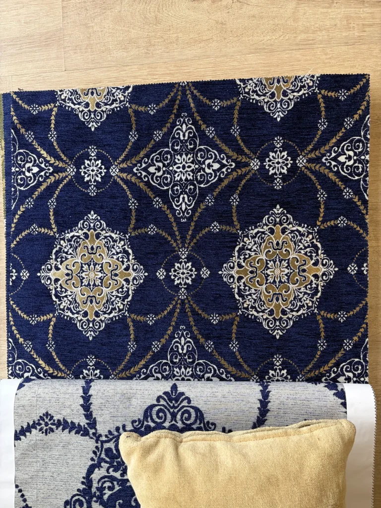 Navy chenille jacquard with repeating white and gold medallions linked by leaf garlands