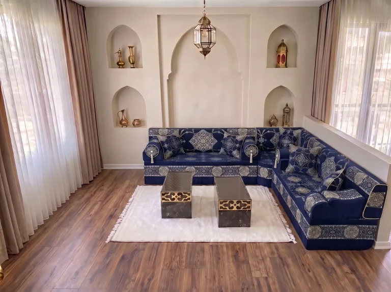 Navy majlis sofa set with silver medallions in an L shape, white fringed rug and two black-and-gold coffee tables
