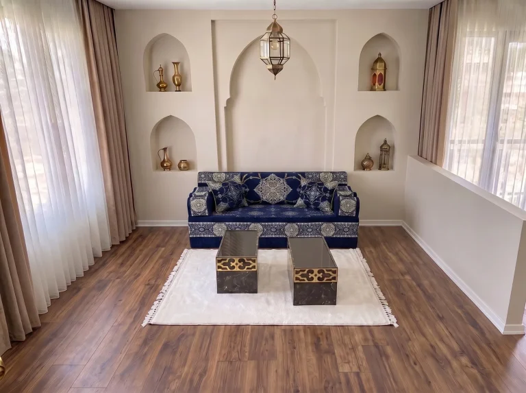 Single-row navy Arabic majlis with silver medallions centred under an arched niche wall, with white rug and two tables