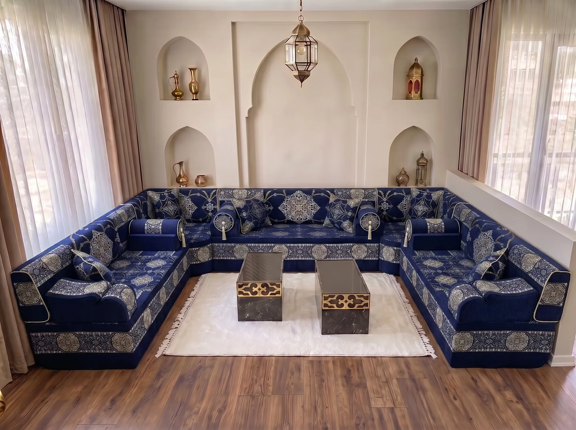 Navy Arabic majlis with silver medallions wrapping three walls in a U shape around a white rug and two coffee tables