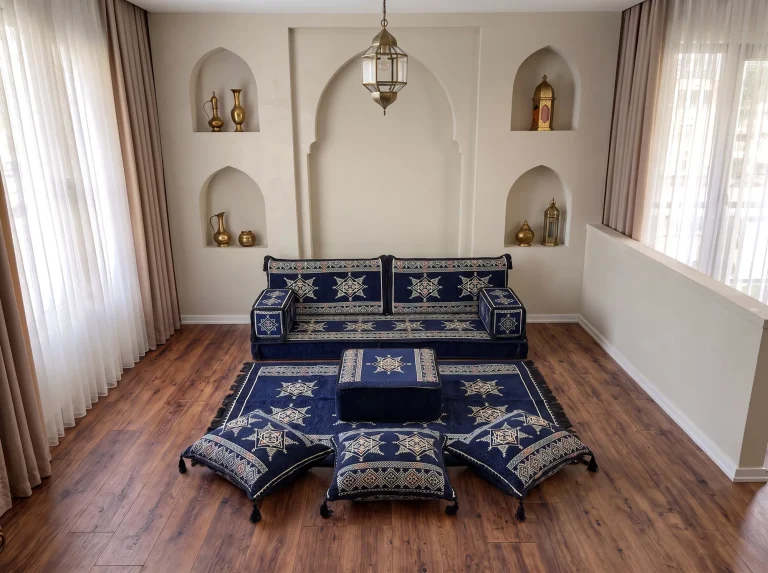 Single-row navy Arabic floor couch with cream stars beneath an arched niche wall, with rug, ottoman and three floor cushions