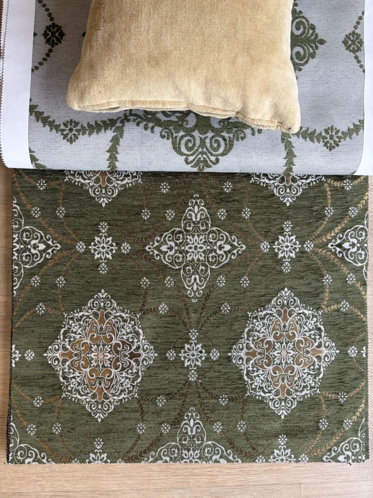 Olive green chenille jacquard upholstery fabric with repeating white medallions and gold leaf garlands