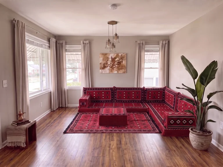 Red sadu-weave floor seating set in an L shape with a matching rug and ottoman in a grey-walled living room