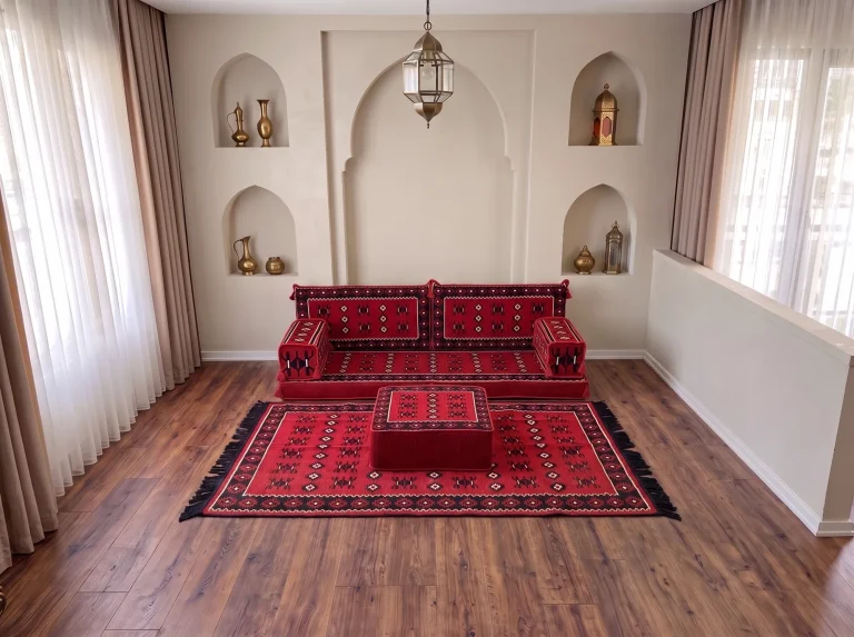 Red sadu-weave floor seating set in a single row with a matching rug and square ottoman below arched niches