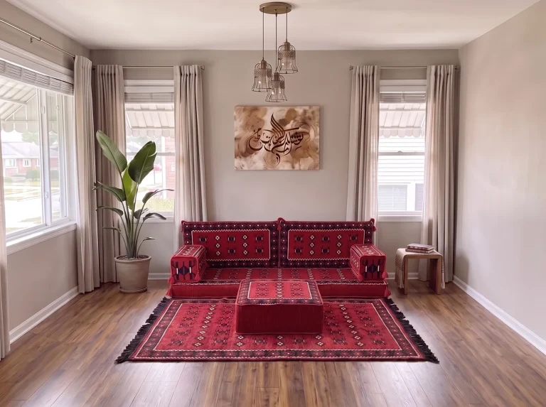 Red sadu-pattern floor seating set in a single row with a matching rug and ottoman under Arabic calligraphy art