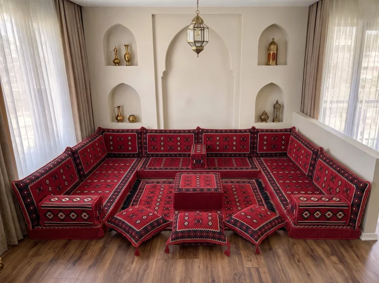 Red Arabic floor sofa in black and white sadu weave lining three walls in a U shape, with rug, ottoman and floor cushions