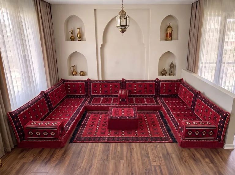 Red floor sofa set in sadu weave arranged in a U shape, with a matching rug and ottoman in the middle