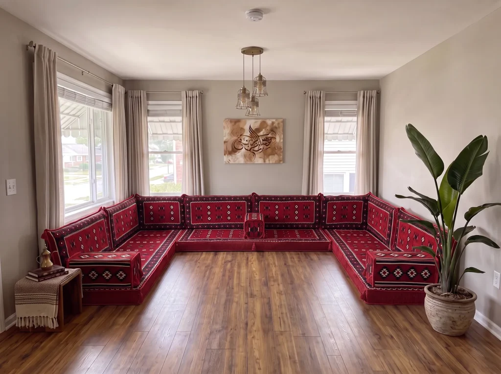 Red sadu-weave Arabic sofa in a U shape along three walls of a grey living room