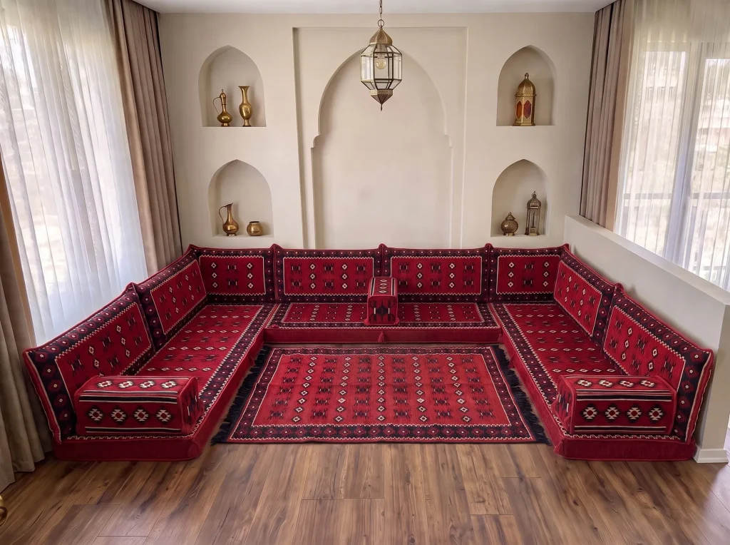 Red sadu-weave Arabic floor sofa in a U shape enclosing a matching red rug with black fringe