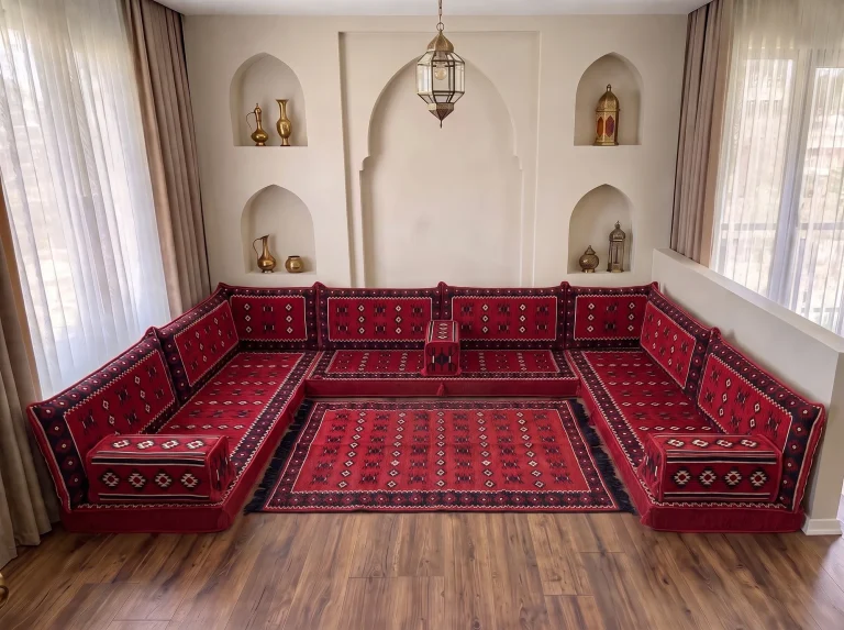 Red sadu-weave Arabic floor sofa in a U shape enclosing a matching red rug with black fringe