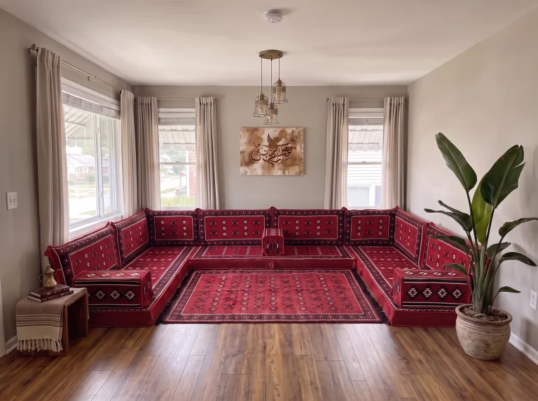 Red Arabic floor sofa in sadu weave arranged in a U shape around a matching rug in a grey living room