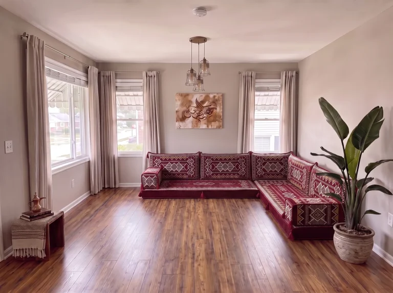 Burgundy and cream kilim L-shaped Arabic floor sofa on a bare wood floor in a grey living room