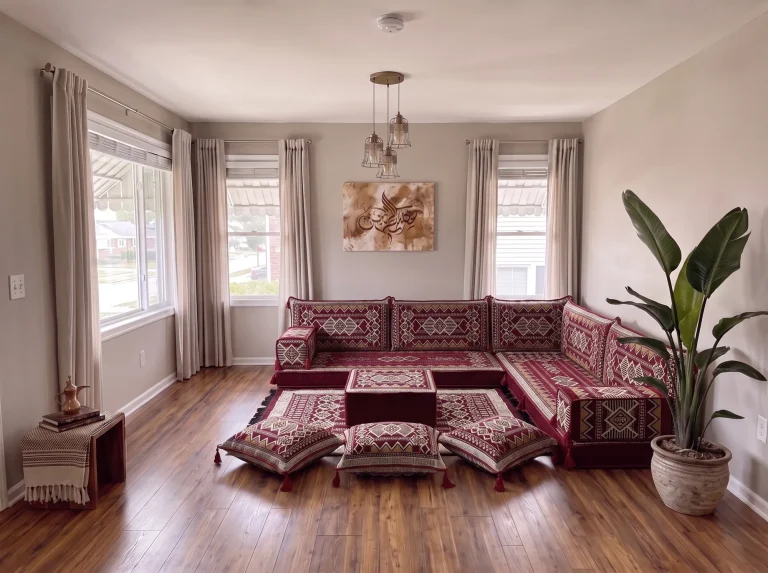 Burgundy and cream kilim L-shaped Arabic floor sofa with rug, ottoman and floor cushions in a grey living room
