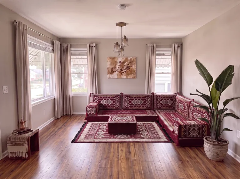 Burgundy and cream kilim L-shaped Arabic floor couch with matching rug and ottoman in a grey living room