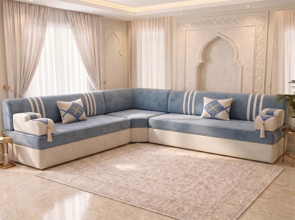 L-shaped sky blue Arabic jalsa with cream base, white-striped backs and two diamond cushions by a cream rug