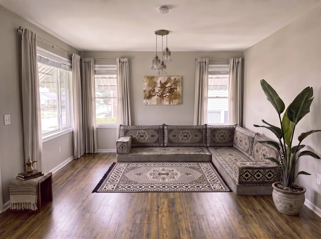 Gray-taupe medallion Arabic floor sofa in an L shape with a matching rug, in a living room with cool gray lighting