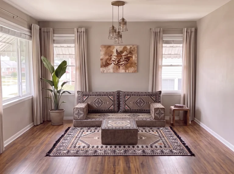 Taupe and black kilim single-row Arabic floor sofa with matching rug and ottoman in a sunlit living room