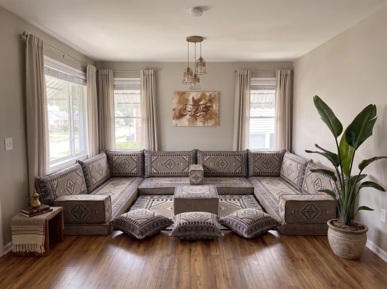 Taupe and black kilim U-shaped floor sofa set with rug, ottoman and floor cushions in a sunlit living room