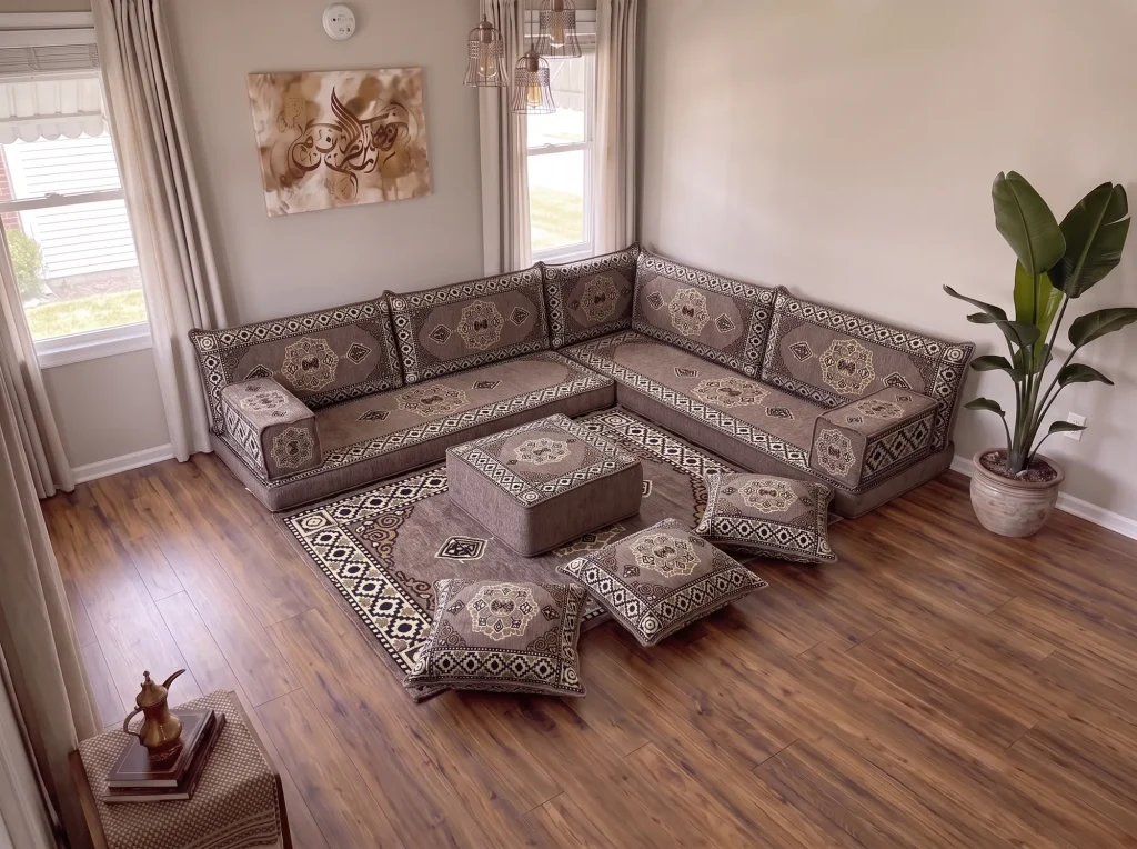 Taupe medallion L-shaped floor sofa set with rug, ottoman and floor cushions in a neutral living room, high corner view
