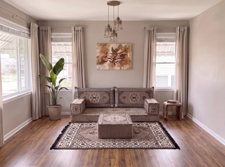 Taupe medallion single-row Arabic floor couch with matching rug and ottoman in a neutral living room, close view