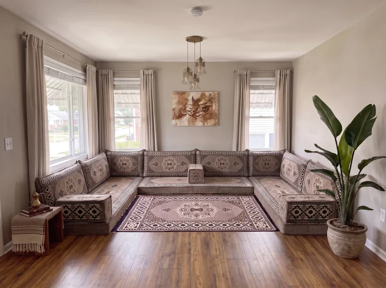 Taupe medallion U-shaped Arabic floor couch with a matching fringed rug in a neutral living room