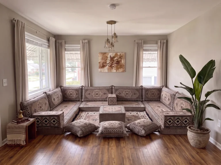 Taupe medallion floor sofa set in a U shape with ottoman, matching rug and three floor cushions in a living room