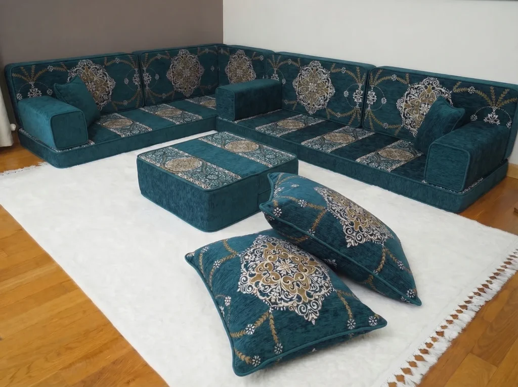 Teal medallion floor seating set in an L shape with an ottoman and two stacked cushions on a white rug